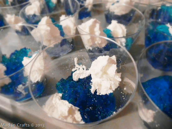 closeup of plastic cups filled with blue jello and whipped cream