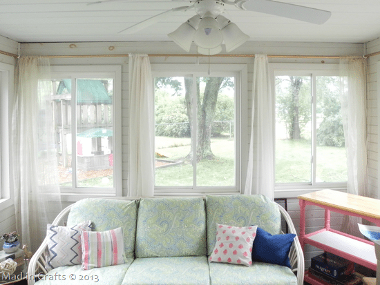 Sheer curtains hanging on the windows of a sunroom