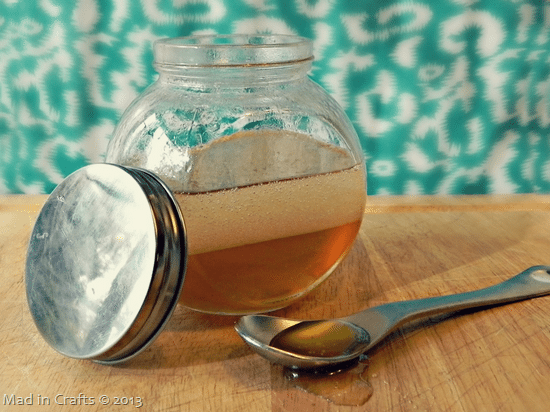 open jar of honey and coconut oil hair mask near a spoonful of honey