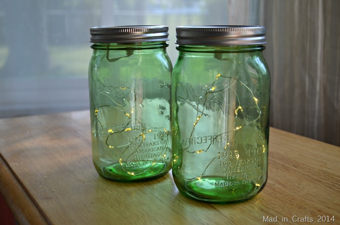 Two green mason jars filled with mini LED lights indoors
