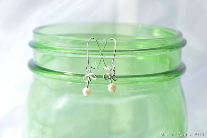 wire and pearl shamrock earrings hanging on a green mason jar