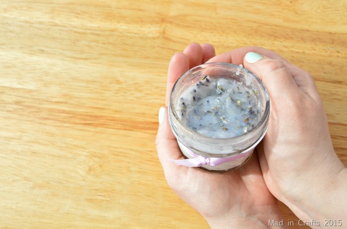 White woman's hands holding an open jar of lavender oil