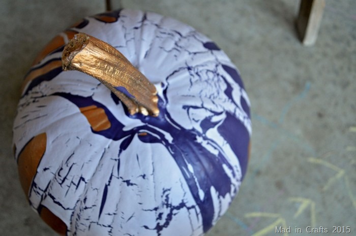 bronze pumpkin stem peeking out of the paint poured over the pumpkin