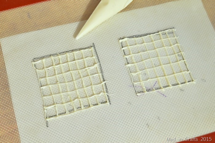 piped white chocolate on a silicone mat on top of drawn squares 