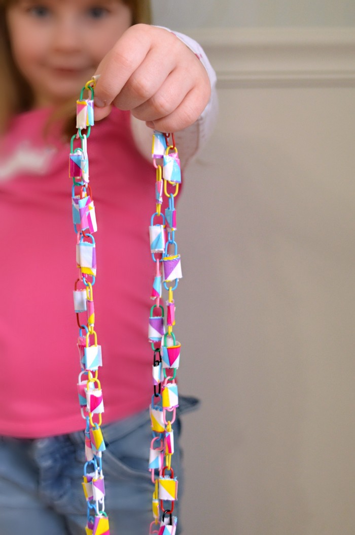 girl holding a necklace made from duct tape and paperclips