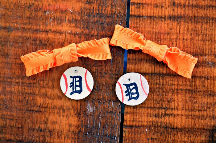 orange bows and painted wood baseballs on a wood table
