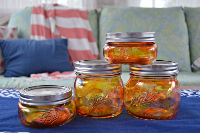 Orange Alcohol Ink Pumpkin Mason jars on a table with a blue table runner
