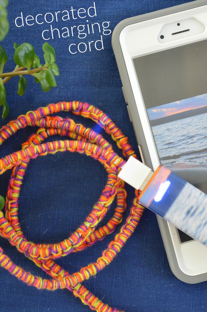 A close up of a cell phone and a personalized portable charger cord