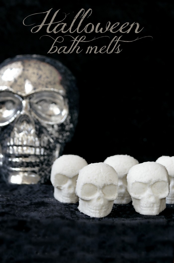 white skull shaped bath bombs and silver skull on a black background