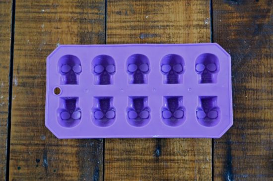 purple silicone skull ice cube tray on a wood table