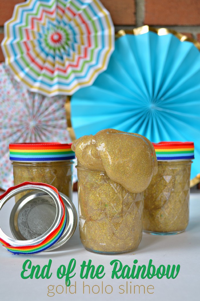 Gold slime in mason jars with rainbow ribbon in front of colorful fans