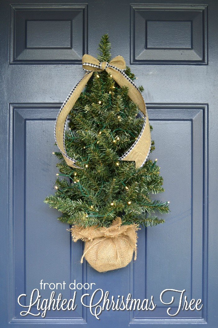 Mini Christmas tree hanging on a blue front door