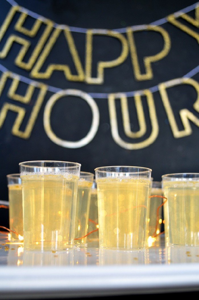 champagne jello shots in front of a happy hour sign
