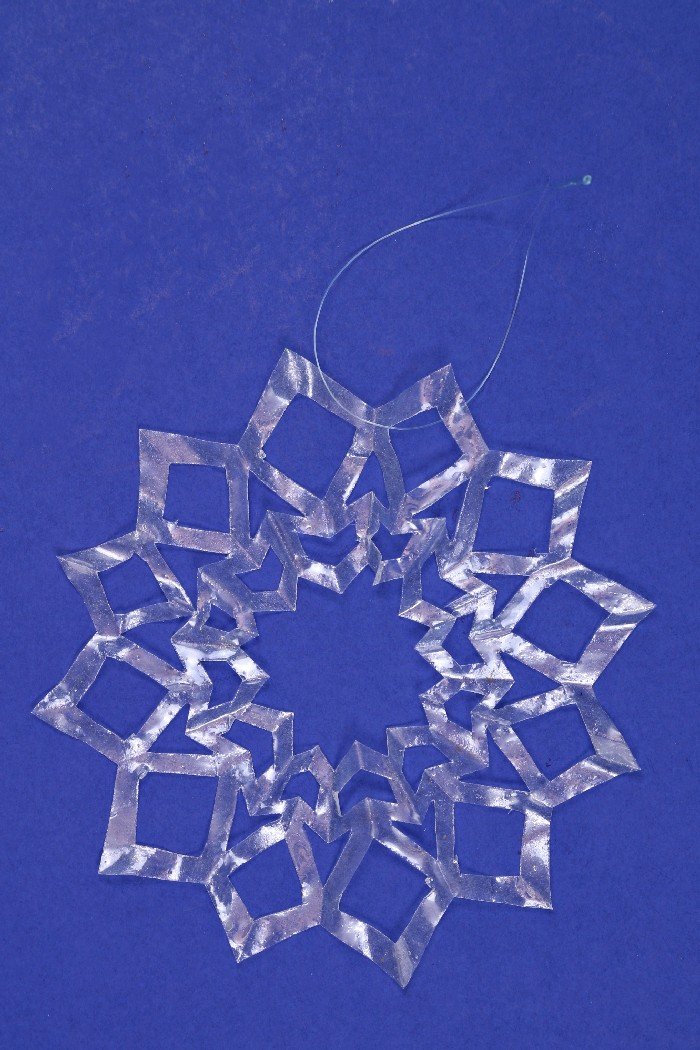 clear coffee filter snowflake ornament on a blue background