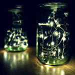 two green mason jars filled with fairy lights