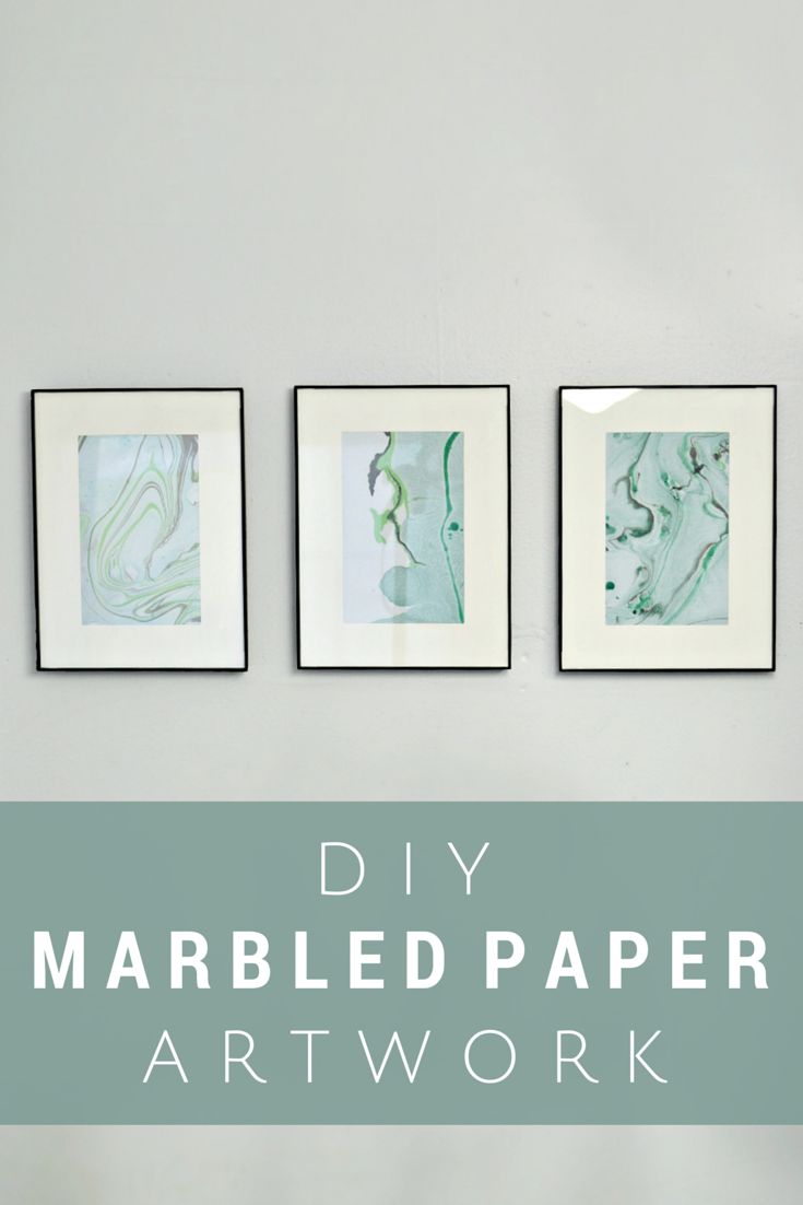 three framed marbled papers on a blue wall