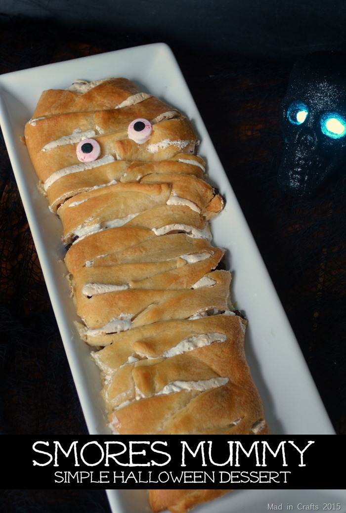 crescent roll mummy dessert on a white platter next to a skull