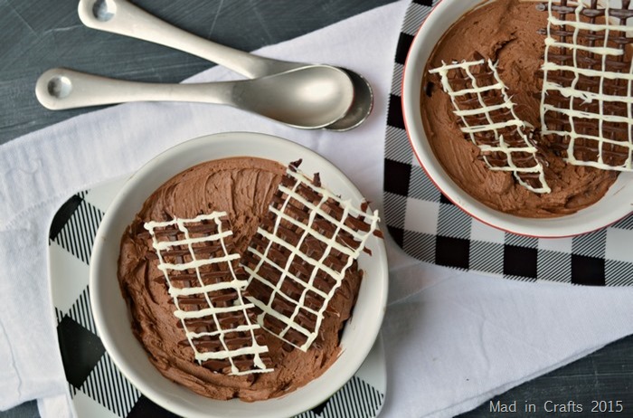 two bowls of chocolate mousse with piped chocolate garnish