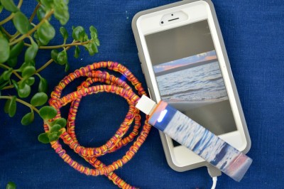 A close up of a cell phone and a colorful charger cable