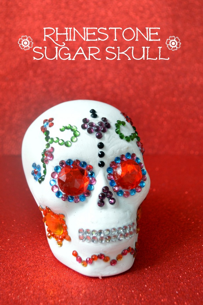 rhinestone Dia de los Muertos skull craft on a red glitter background