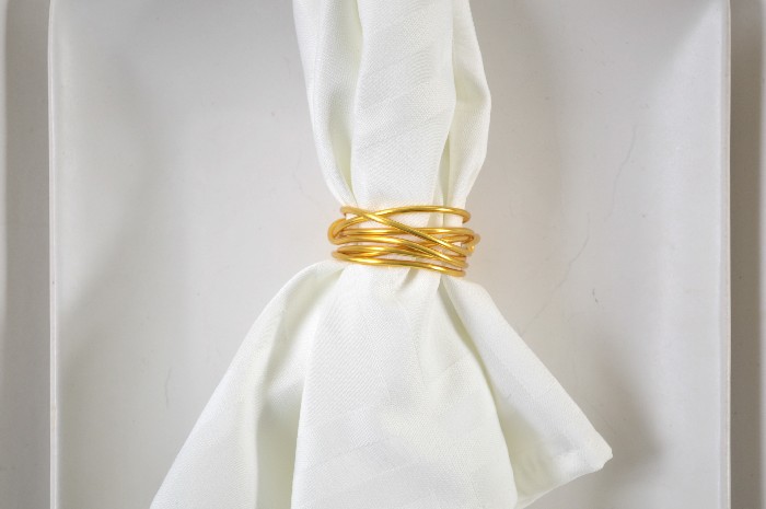 closeup of a wire napkin ring on a white napkin