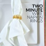 wrapped wire napkin ring holding white napkin on square white plates and a colorful placemat