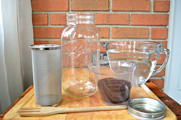 supplies needed to make cold brew in a mason jar: jar strainer, large mason jar, coffee, water, spoon