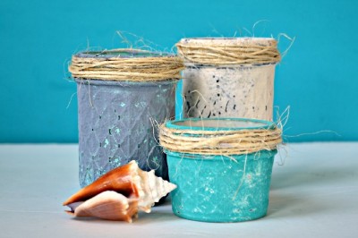 blue and white beachy painted mason jars on a blue background with a seashell