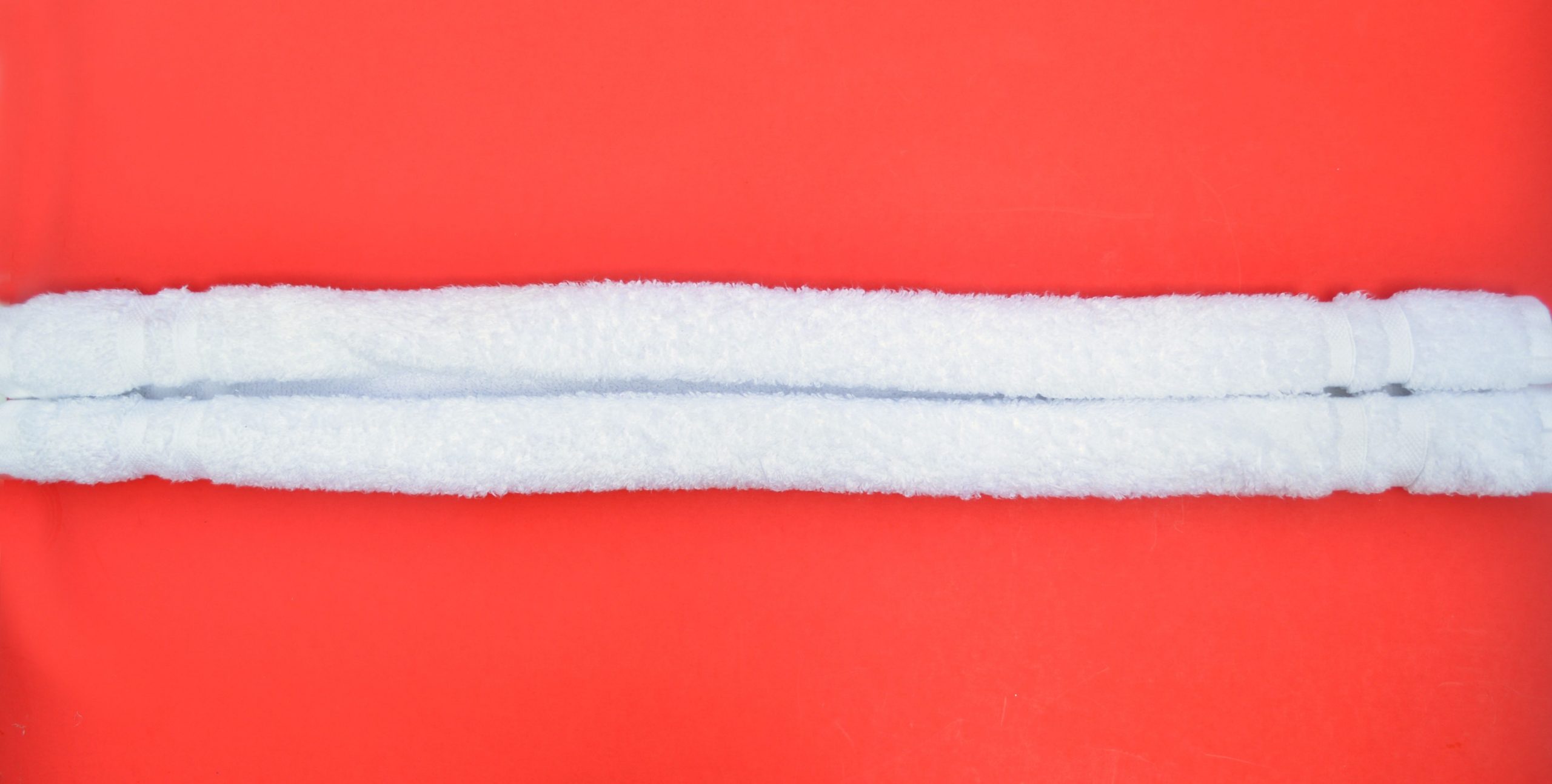 rolled white towel on a red background