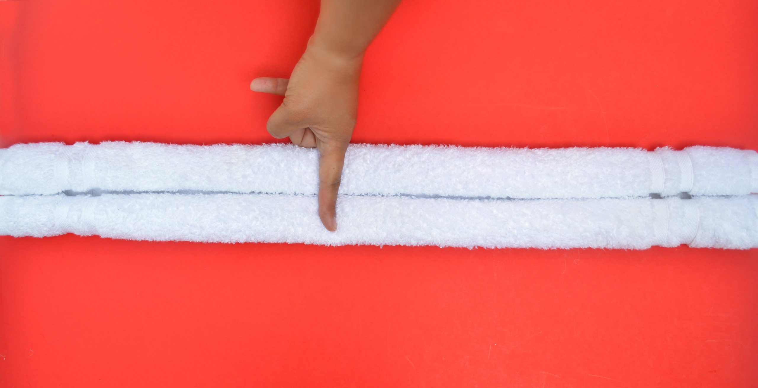 finger on the middle of a rolled towel on a red background