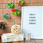 Mason jar ring succulent wreaths hanging next to a letterboard that says Only Good Vibes Today