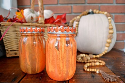 orange and yellow drip painted mason jars next to white pumpkins