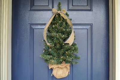 Mini Christmas tree hanging on a blue front door