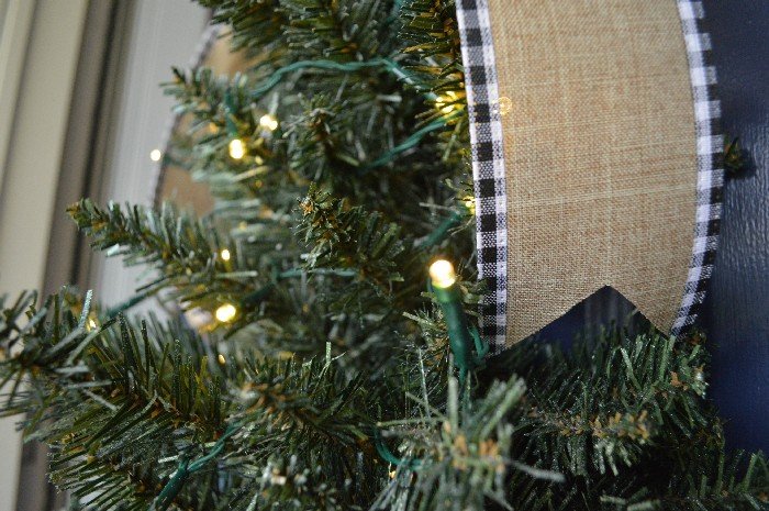 A close up of a Christmas tree hanging on a front door