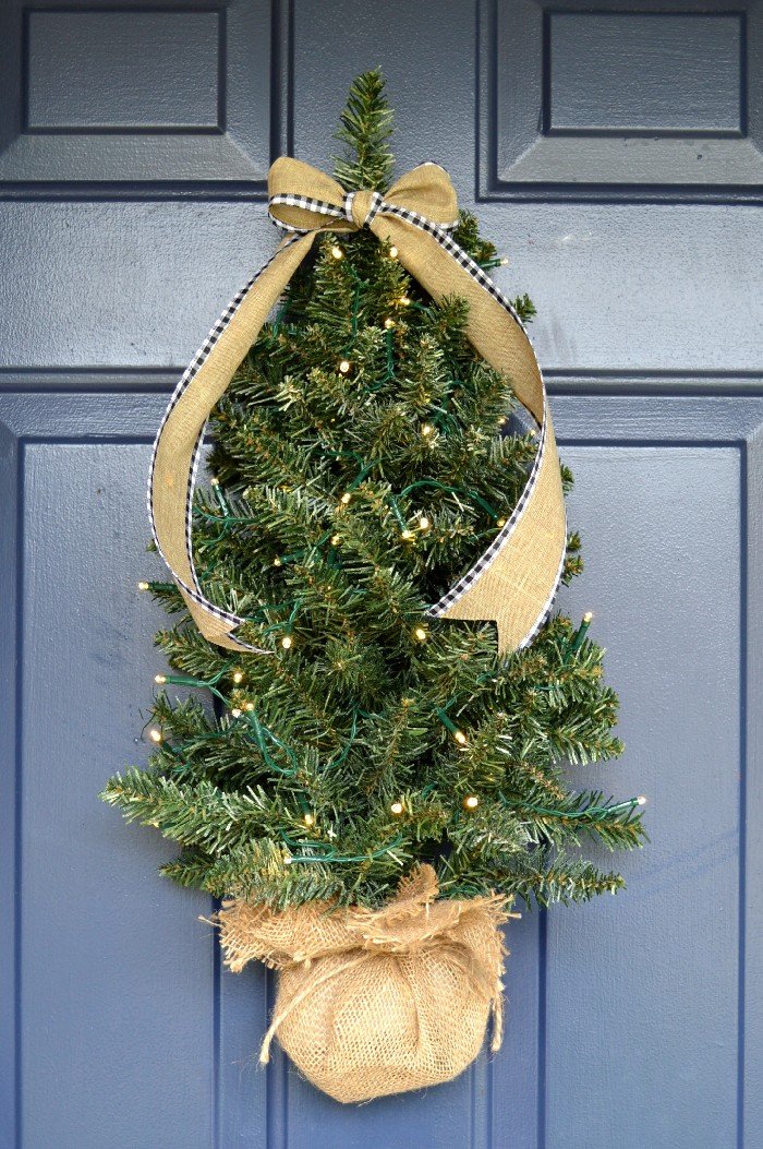 Mini Christmas tree hanging on a blue front door