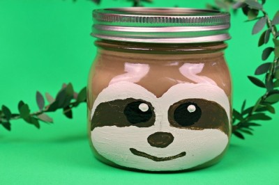 sloth painted mason jar on a green background