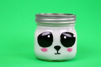 Panda painted mason jar on a green background