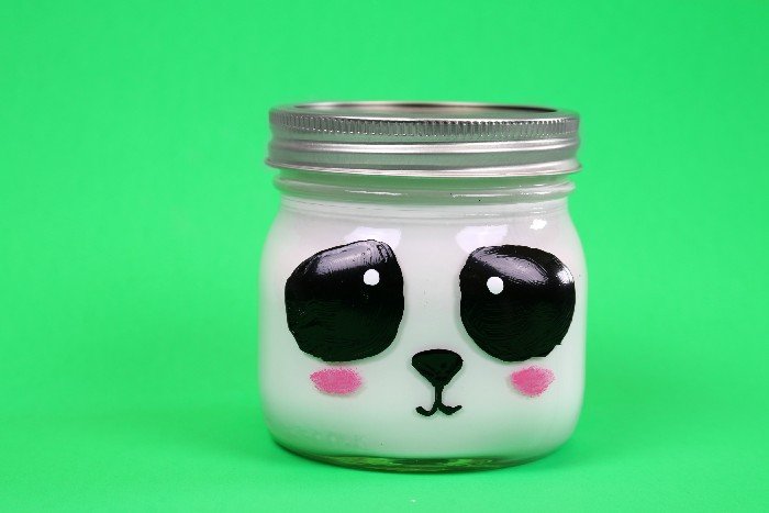 Panda painted mason jar on a green background