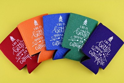 colorful can koozies with iron on vinyl on a yellow background