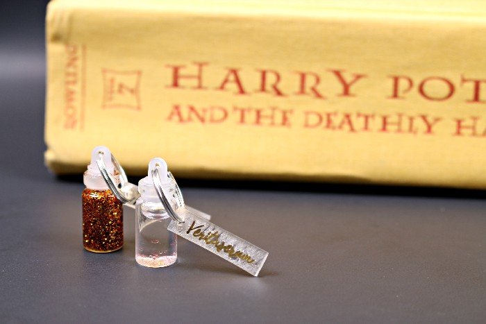 Mini Harry Potter Potion Charms near a copy of Deathly Hallows 