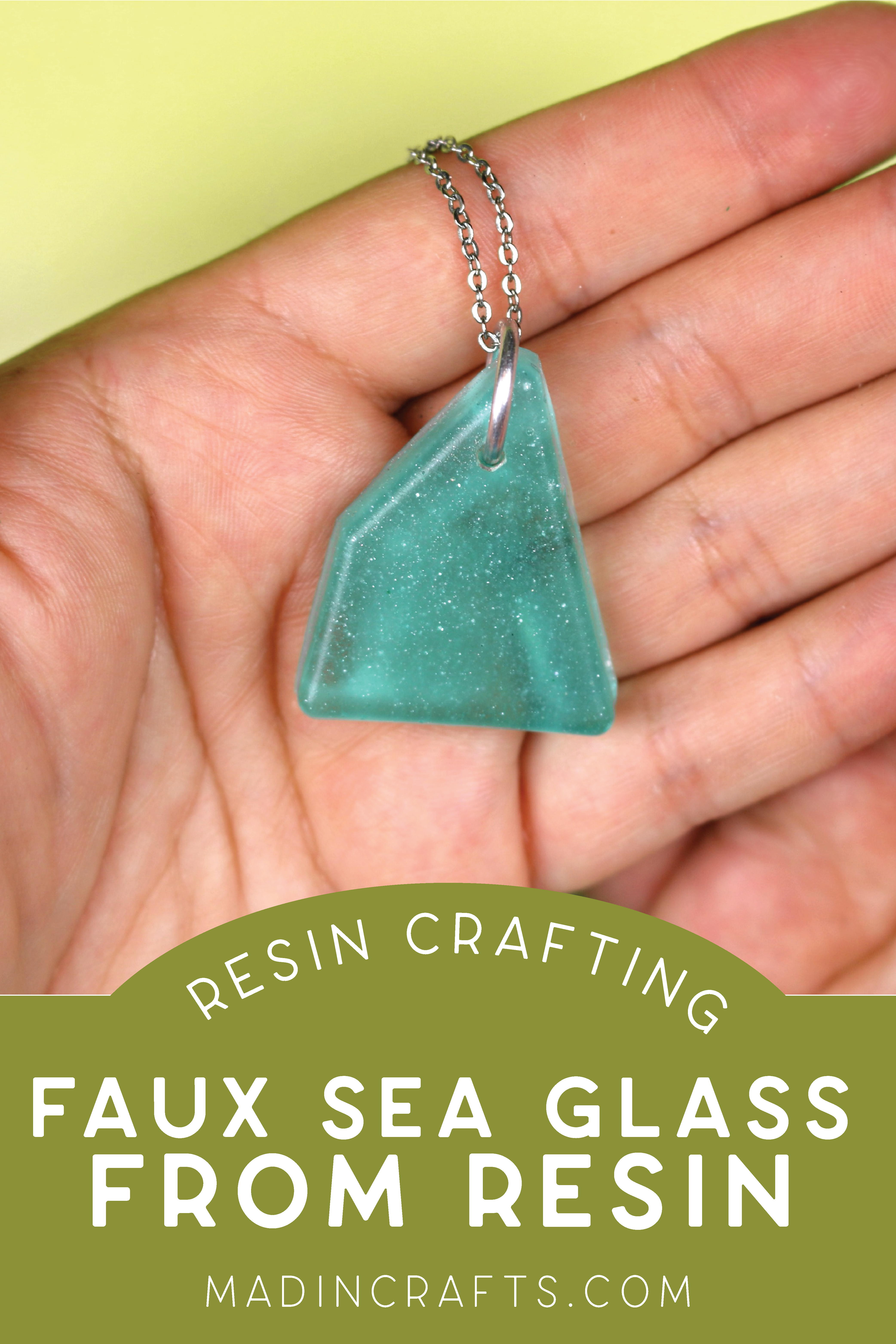 hand holding a faux sea glass pendant