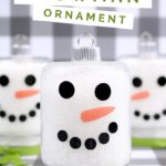 snowman mason jar ornaments on a plaid background