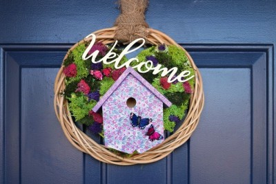 welcome wreath with reindeer moss and a birdhouse on a blue door