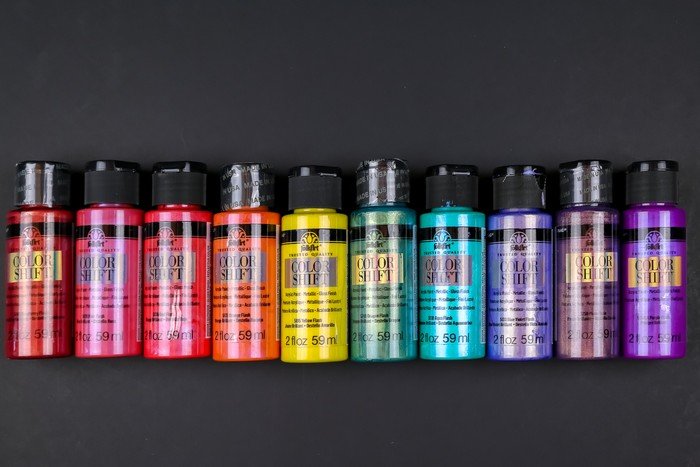 bottles of FolkArt Color Shift paint laid out in rainbow order