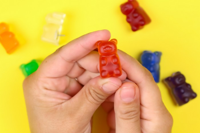 hands holding DIY gummy bear thumbtack