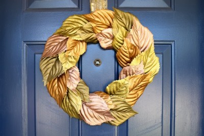 wreath made of metallic painted leaves on a blue door