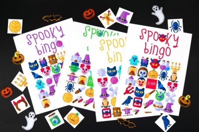 pile of printable halloween bingo cards on a black background