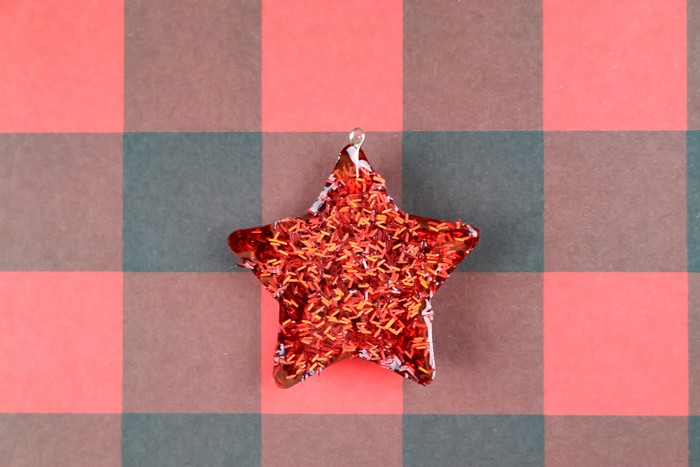 glitter resin star ornament on a plaid background