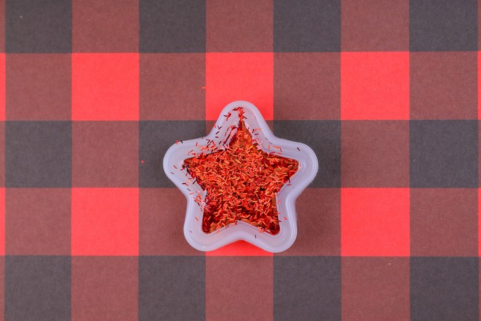 glitter resin in a star mold on a plaid background