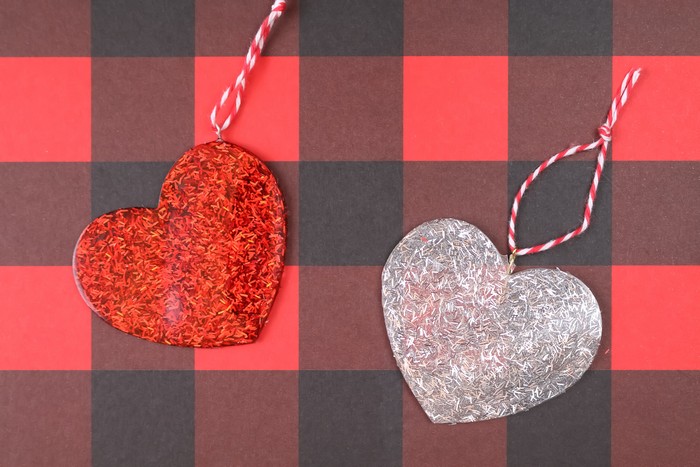 glitter resin heart ornaments on a plaid background
